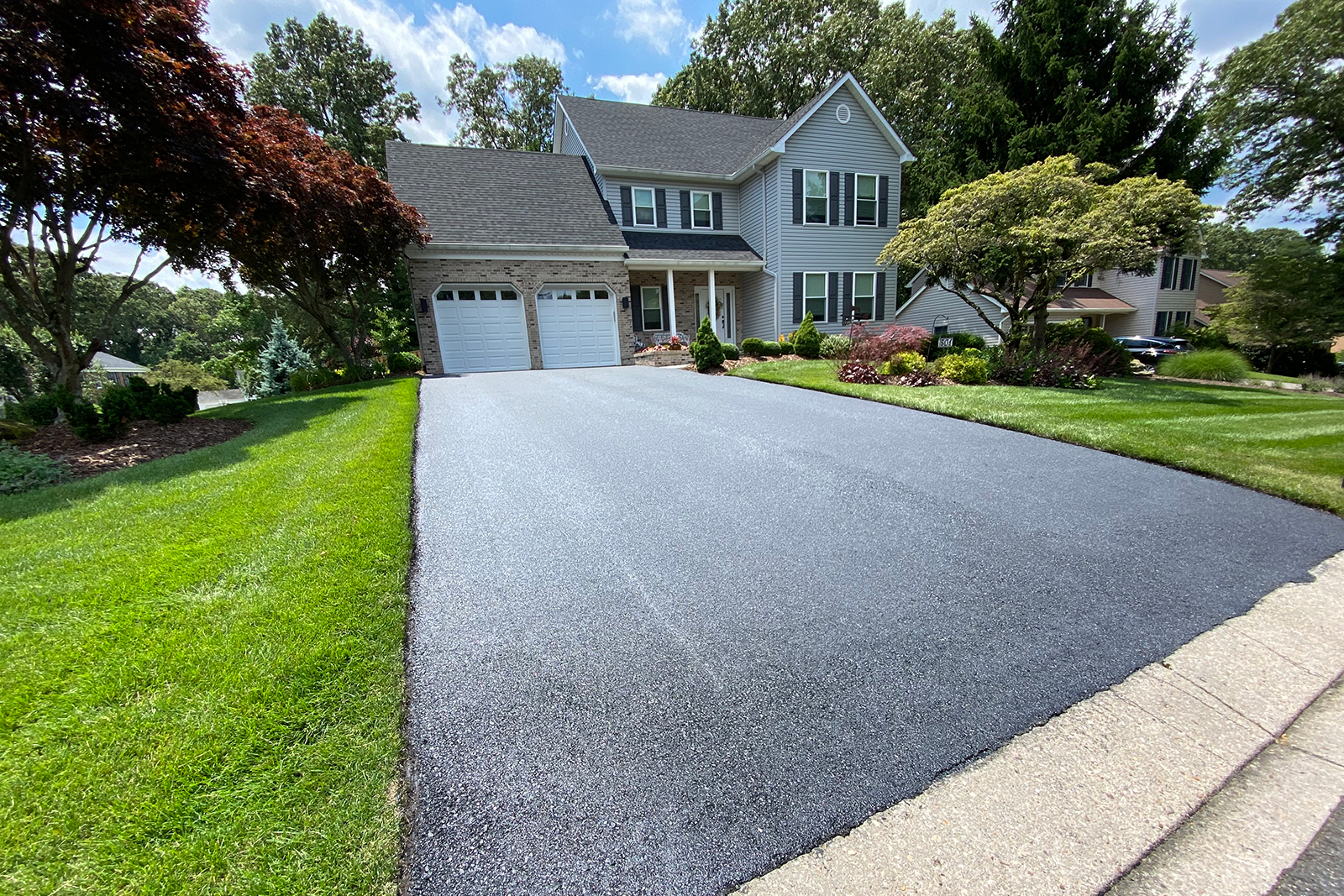 Completed smooth black asphalt surface with professional finish