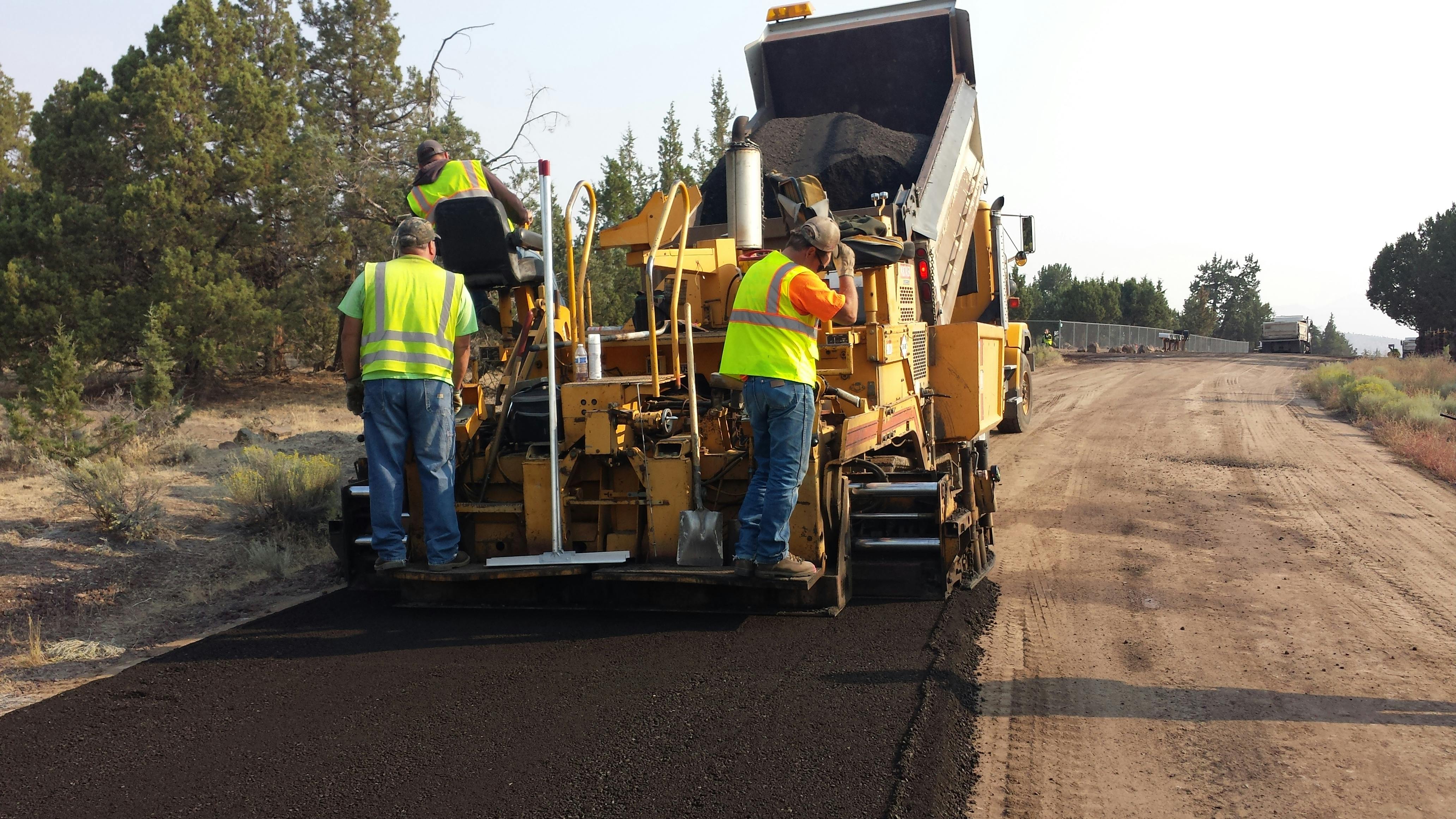 Parking lot maintenance crew performing resurfacing work